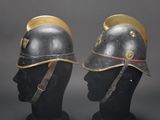 pair of helmets on mannequin heads on display against a gray background