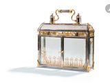 a glass box with a gold handle on a white background