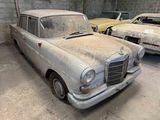 two old cars that are parked in a garage