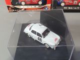 a small white car in a clear box on a table