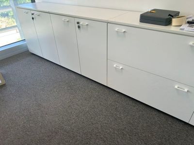 une armoire blanche avec des tiroirs, sur laquelle est posée une imprimante