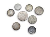 several different types of coins are arranged in a circle on a white surface