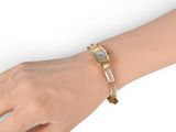 an image of a woman ' s wrist with a watch on it