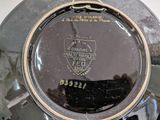 a close up of a silver plate with a black and gold emblem on it