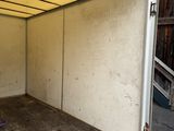 a white trailer with a door open in a garage