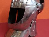 un casque argenté sur un fond rouge, avec un mur en arrière-plan
