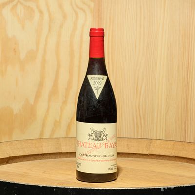 une bouteille de vin posée sur un tonneau