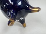a blue vase that has a gold decoration on it