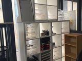 a desk with a chair and a book shelf in the corner