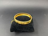 un gros plan d'une bague en or posée sur un sac noir