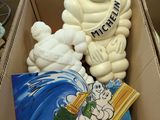 a cardboard box with a statue of a man and a teddy bear in it