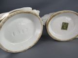 two white porcelain vases with gold trims and a green square on the top