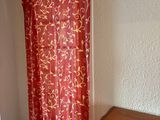 a red curtain hanging in a corner of a room