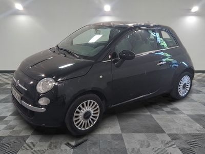 la photo d'une petite voiture noire sur un sol en damier