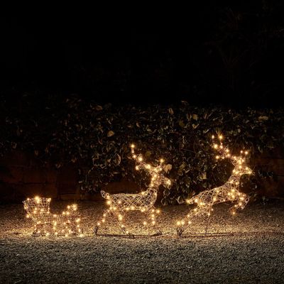 lighted reindeer sleigh and sleigh with lights in the dark