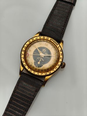 une vieille montre-bracelet posée sur une surface blanche