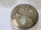 a silver container with a design on it on a table