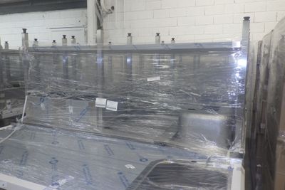de nombreux rouleaux de film alimentaire sur un tapis roulant dans une usine