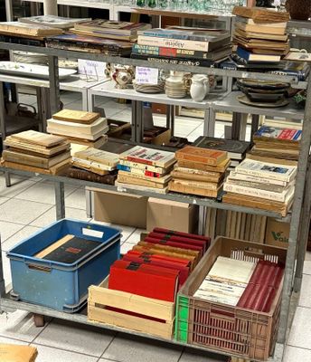 many boxes of books on a shelf in a room
