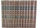six livres marron aux bords noirs et dorés sont alignés sur une surface blanche