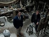 two men standing in the middle of a room full of stuff