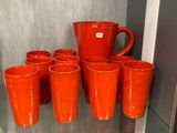 de nombreuses tasses et un pichet posés sur une étagère dans une pièce