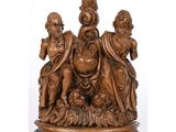 figurine en bois sculpté représentant trois enfants assis sur un globe terrestre