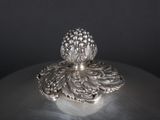 an antique silver plate with a pineapple on top of it