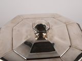 a silver plate with a lid on it on a table