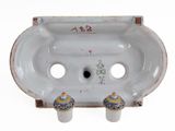 a white porcelain sink with two blue and yellow vases on it