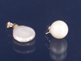 paire de boucles d'oreilles en perles et or sur fond noir avec reflets