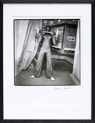 black and white photograph of a man standing in front of a curtain