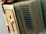 un petit livre orné d'une croix, accroché au mur