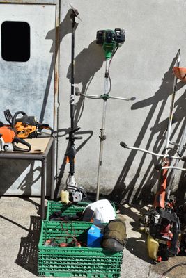 many skis and snowboards on the ground next to a building