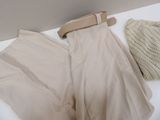 a pair of pants and a hat sitting on a bed