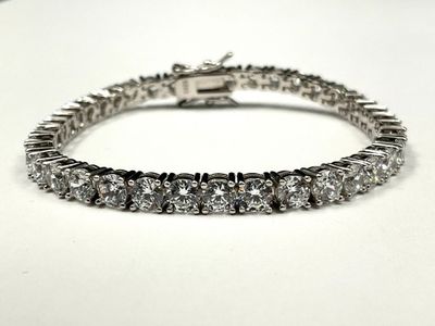 a close up of a diamond bracelet on a white surface