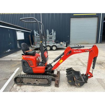 a small red excavating machine parked in a parking lot