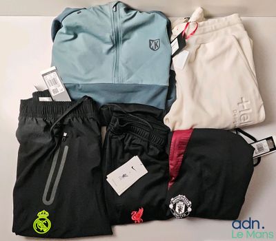 a pile of clothing that includes a jacket, pants, and a watch