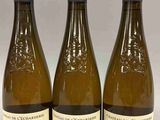 trois bouteilles de vin posées sur une table l'une à côté de l'autre