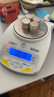 une balance posée sur une table, avec des pièces de monnaie dessus