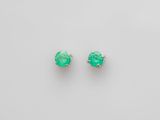 une paire de boucles d'oreilles en émeraude sur fond blanc