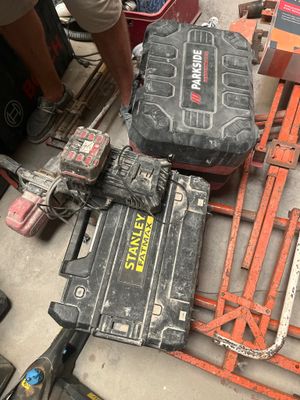 un homme qui se tient à côté d'un tas d'outils