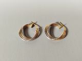 a pair of gold hoop earrings on a white surface