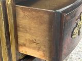 a wooden chest of drawers with brass hardware on it