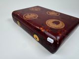 a red case with gold designs on it on a white surface