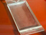 un plateau en verre posé sur une table rouge, sur lequel se trouve un téléphone portable
