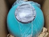 a blue ball in a cardboard box that is wrapped in plastic