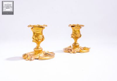 deux bougeoirs dorés sur fond blanc