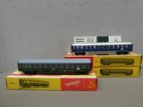 Plusieurs petits trains sont posés sur des cartons, sur une table.
