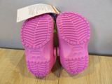 purple rubber shoes with pink soles on a wooden surface